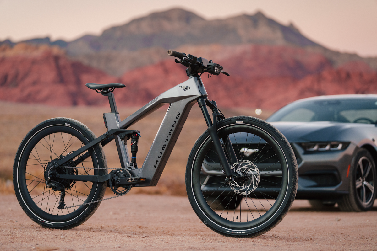 Mustang eBike in a desert setting with a Mustang vehicle out of focus in the background. Used to illustrate open-road riding.